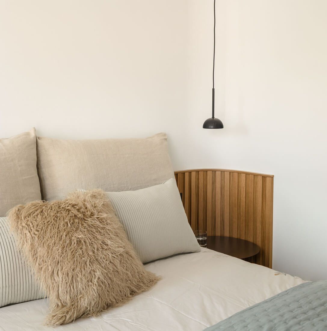 Mesilla con lámpara decorativa en dormitorio reformado