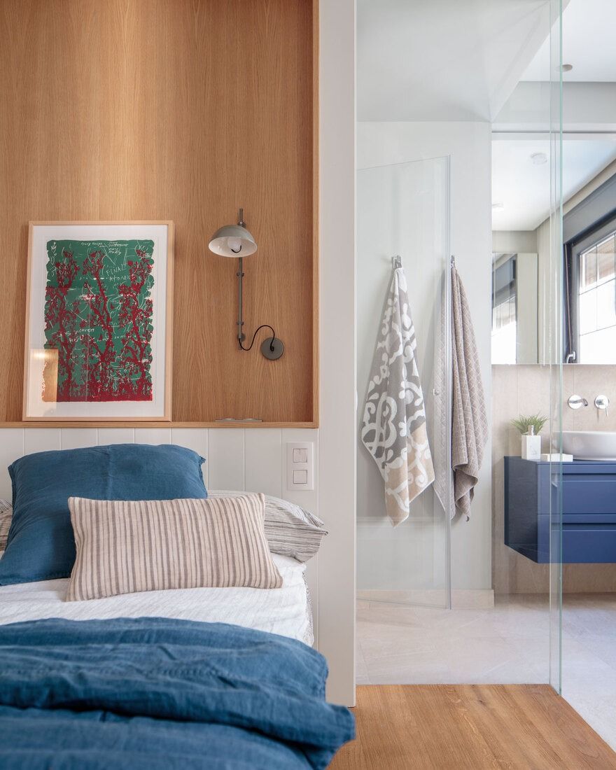 Cama junto a lavabo en dormitorio reformado